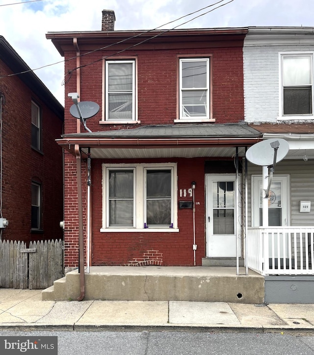 119 E Scull St, Lebanon, PA 17046 - townhome / multi-family property with a chimney, covered porch, fence, and brick siding