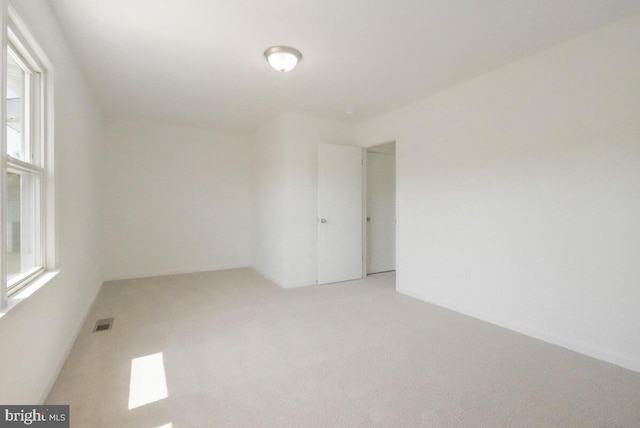 empty room with visible vents and light carpet