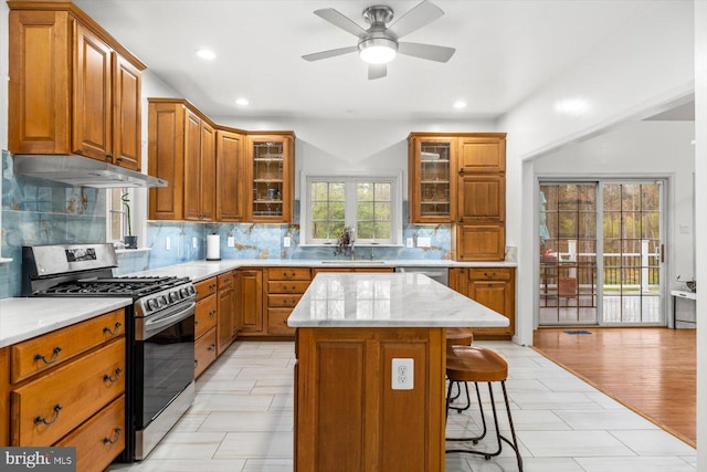 kitchen featuring under cabinet range hood, brown cabinets, and appliances with stainless steel finishes