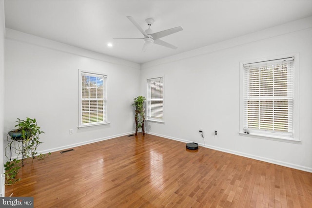 spare room featuring visible vents, baseboards, and wood finished floors