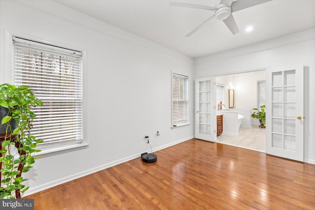spare room featuring french doors, baseboards, a ceiling fan, and wood finished floors