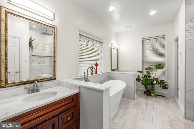 bathroom featuring recessed lighting, vanity, walk in shower, and a soaking tub