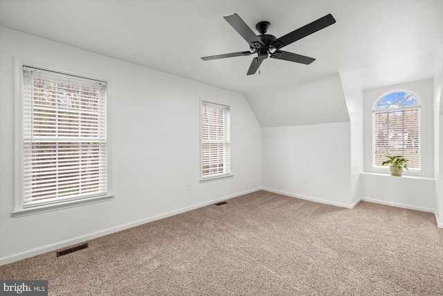 bonus room with baseboards, vaulted ceiling, carpet flooring, a ceiling fan, and visible vents
