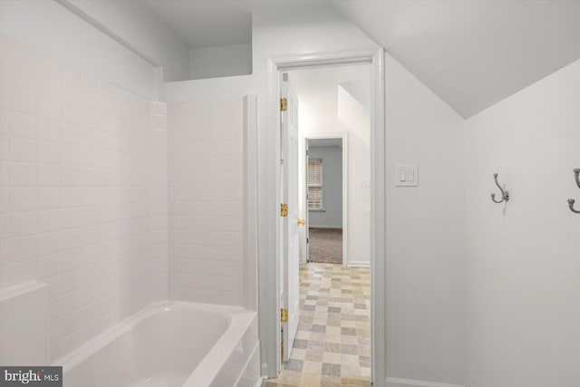bathroom with baseboards and lofted ceiling
