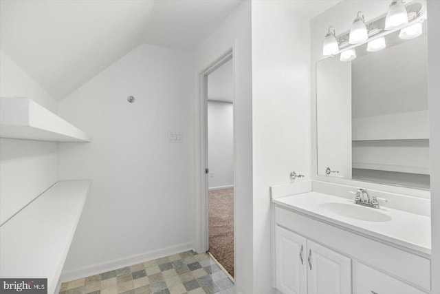 bathroom with vanity, baseboards, and lofted ceiling