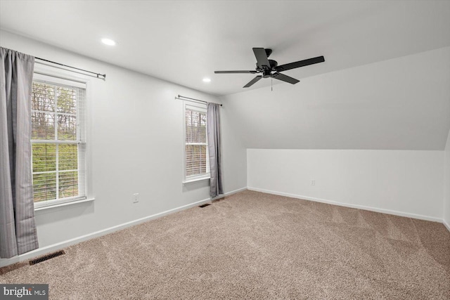 spare room with carpet, visible vents, and a wealth of natural light