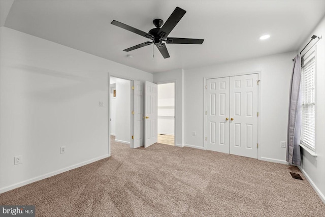 unfurnished bedroom featuring baseboards, multiple windows, visible vents, and carpet floors
