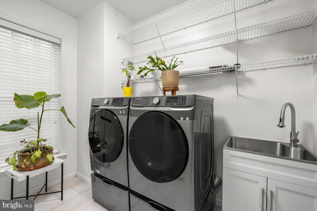 laundry area with independent washer and dryer, baseboards, a sink, and cabinet space