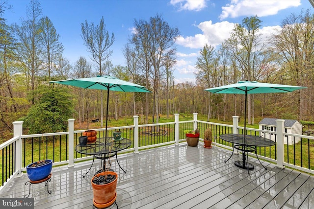 wooden deck with an outdoor structure and a lawn