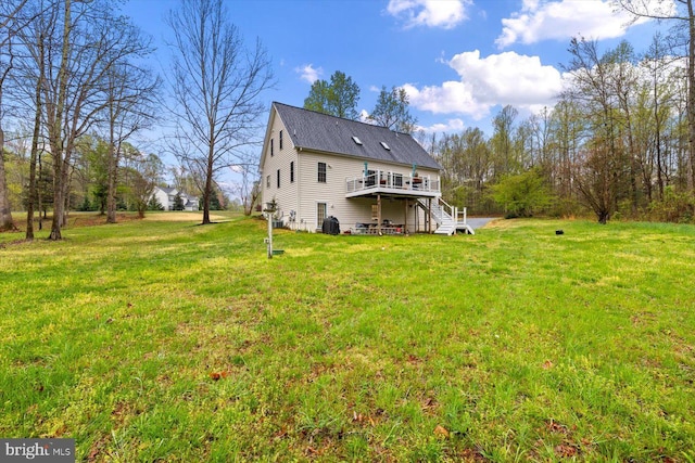 back of property featuring a lawn, a wooden deck, and stairway