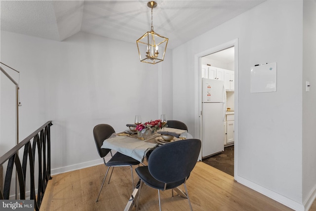 2201 L St NW Unit 515, Washington, DC 20037 - dining space featuring wood finished floors, a chandelier, and vaulted ceiling