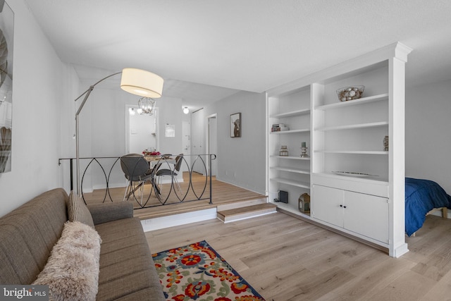2201 L St NW Unit 515, Washington, DC 20037 - living area featuring light wood finished floors, a chandelier, and built in shelves