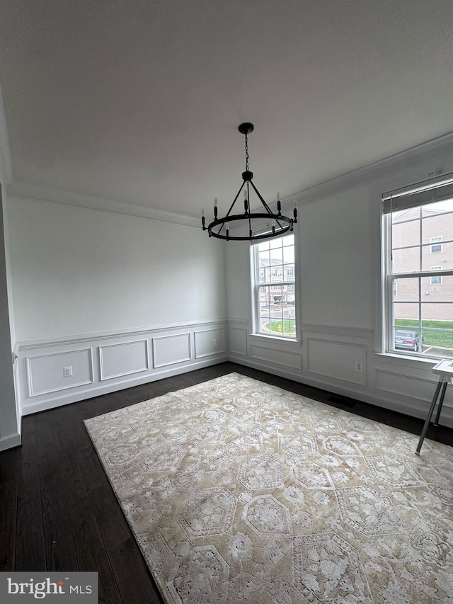 8676 Underhill Ln, Manassas, VA 20112 - unfurnished dining area with dark wood-type flooring, crown molding, an inviting chandelier, and a wainscoted wall