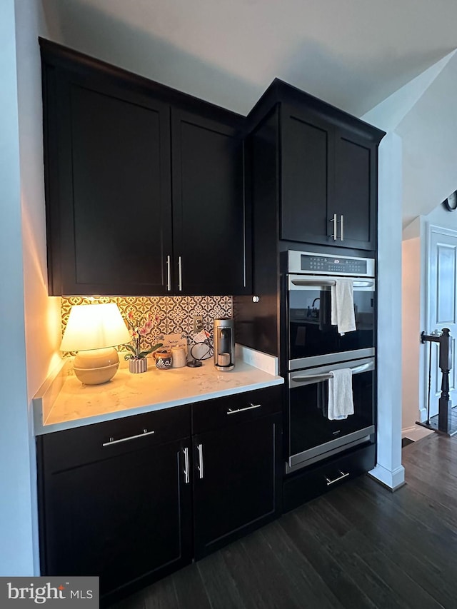 8676 Underhill Ln, Manassas, VA 20112 - kitchen featuring light countertops, dark cabinetry, dark wood finished floors, double oven, and backsplash
