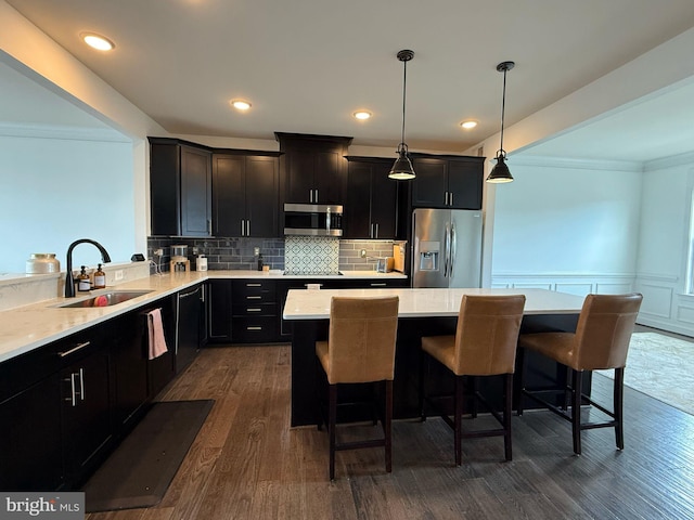8676 Underhill Ln, Manassas, VA 20112 - kitchen with a center island, a sink, a breakfast bar, crown molding, and stainless steel appliances