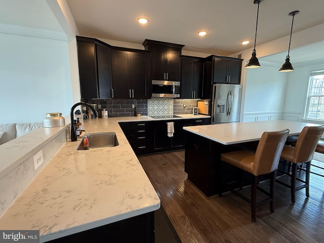 8676 Underhill Ln, Manassas, VA 20112 - kitchen featuring dark wood-style flooring, a kitchen breakfast bar, decorative backsplash, stainless steel appliances, and a sink