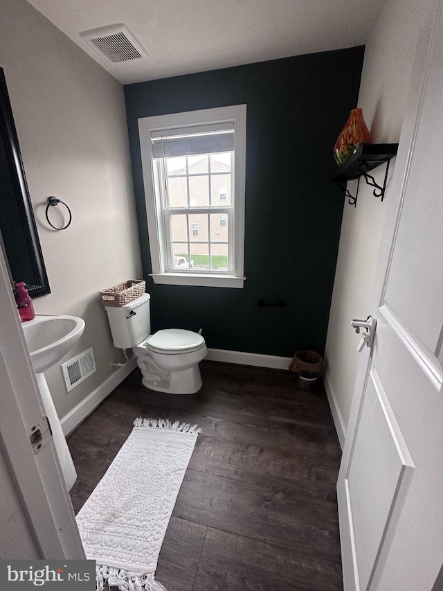 8676 Underhill Ln, Manassas, VA 20112 - half bathroom featuring visible vents, toilet, wood finished floors, and baseboards