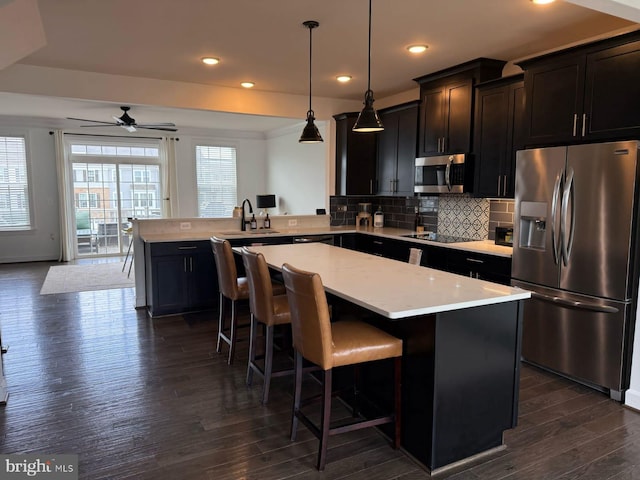 8676 Underhill Ln, Manassas, VA 20112 - kitchen with tasteful backsplash, a sink, light countertops, a peninsula, and stainless steel appliances