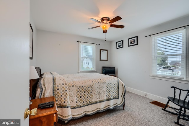 carpeted bedroom with baseboards and a ceiling fan