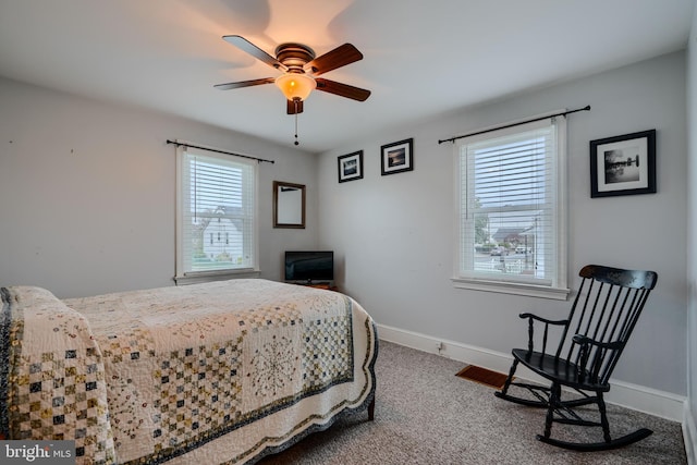 carpeted bedroom featuring baseboards and a ceiling fan