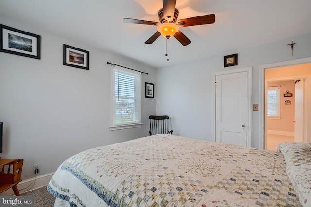 bedroom with a ceiling fan, baseboards, and multiple windows