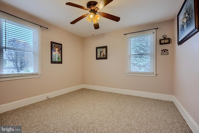 carpeted empty room with a wealth of natural light, baseboards, and a ceiling fan