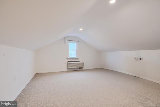 bonus room featuring carpet flooring, baseboards, a wall unit AC, and lofted ceiling