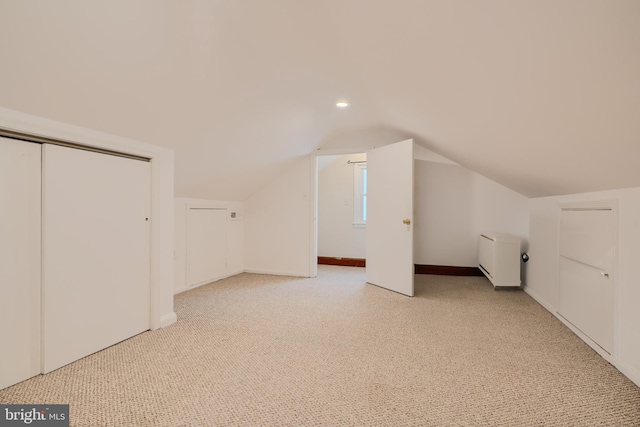 additional living space featuring light carpet, baseboards, vaulted ceiling, and recessed lighting