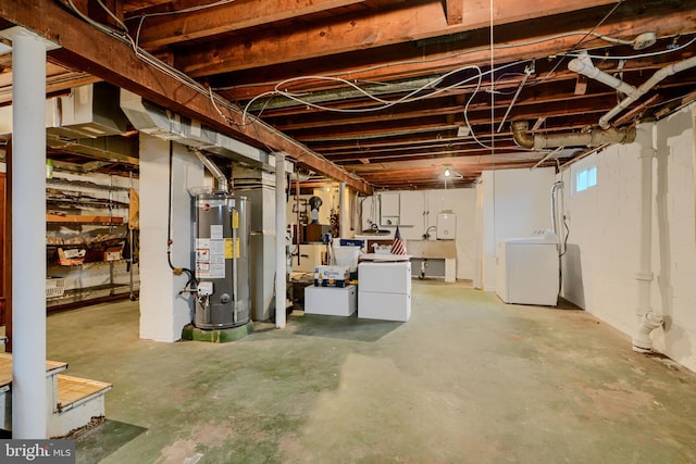 below grade area featuring water heater and washer and dryer