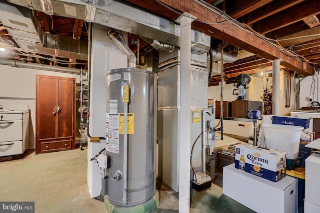 utility room with gas water heater and washer / dryer