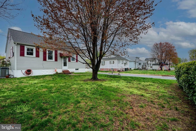 view of yard featuring entry steps, central AC unit, and a residential view