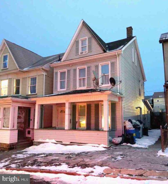 view of front of home with covered porch and a chimney