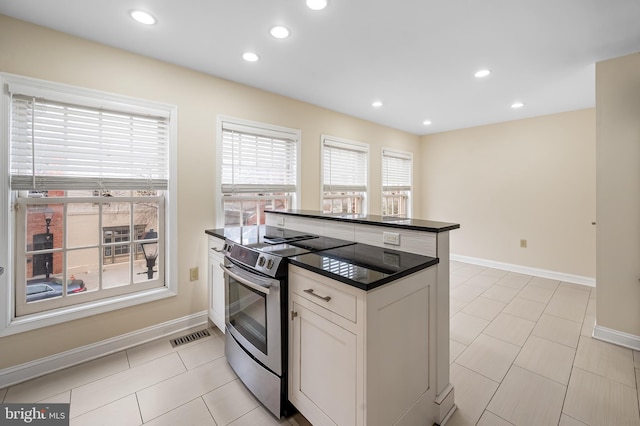 922 Fell St, Baltimore, MD 21231 - kitchen with stainless steel electric stove, white cabinets, recessed lighting, visible vents, and dark countertops