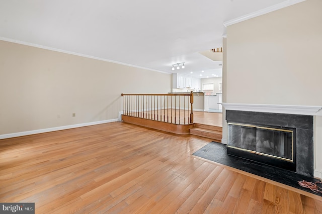 922 Fell St, Baltimore, MD 21231 - unfurnished living room featuring a fireplace with flush hearth, crown molding, baseboards, and light wood-type flooring