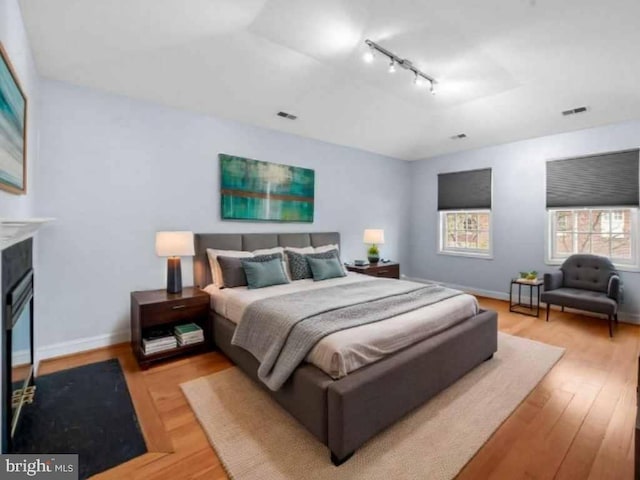 922 Fell St, Baltimore, MD 21231 - bedroom featuring visible vents, track lighting, light wood-style flooring, and baseboards