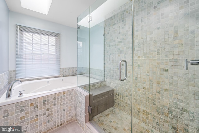 922 Fell St, Baltimore, MD 21231 - bathroom with tile patterned flooring, a garden tub, a stall shower, and a skylight
