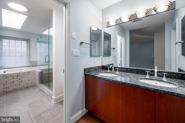 922 Fell St, Baltimore, MD 21231 - full bathroom featuring tile patterned flooring, a bath, a sink, and a skylight