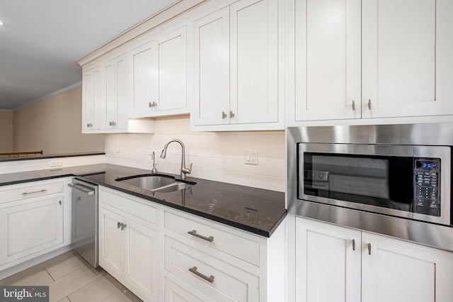 922 Fell St, Baltimore, MD 21231 - kitchen featuring dark stone counters, tasteful backsplash, ornamental molding, appliances with stainless steel finishes, and a sink