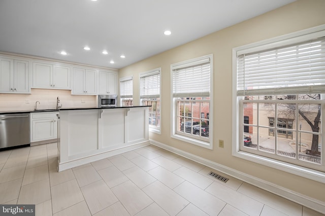 922 Fell St, Baltimore, MD 21231 - kitchen with stainless steel appliances, visible vents, white cabinets, and dark countertops