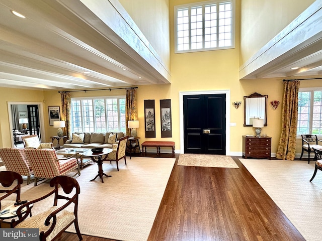 entryway with baseboards, beamed ceiling, and wood finished floors