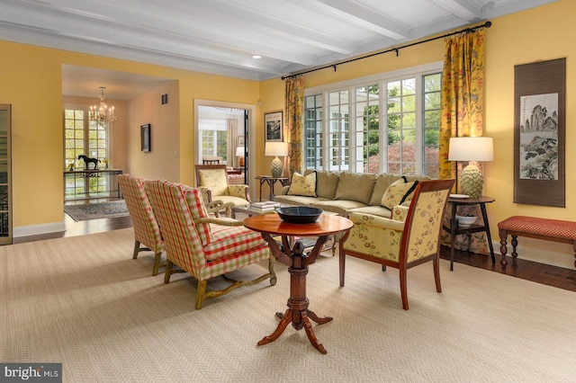 living room featuring a wealth of natural light, a notable chandelier, baseboards, and beam ceiling