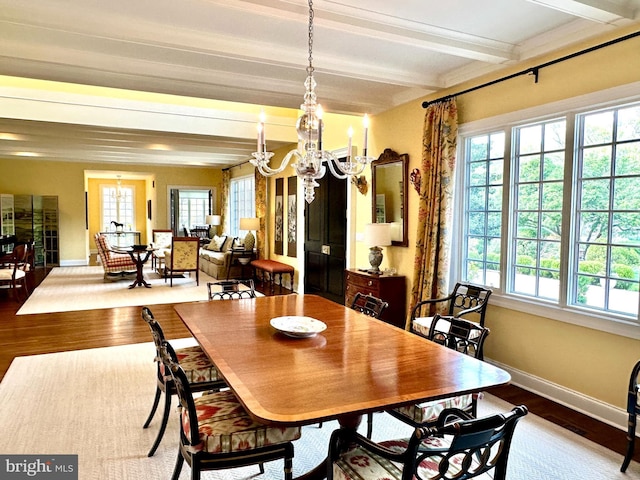dining area with beamed ceiling, baseboards, an inviting chandelier, and wood finished floors