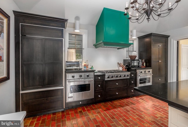 kitchen with custom range hood, dark brown cabinetry, an inviting chandelier, dark countertops, and appliances with stainless steel finishes