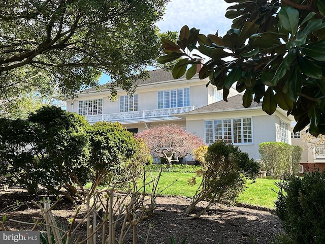 exterior space featuring stucco siding and a front lawn