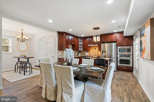 dining room featuring dark wood-type flooring, baseboards, recessed lighting, and a chandelier