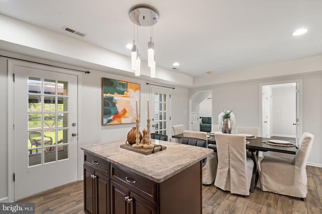 kitchen with dark brown cabinets, wood finished floors, visible vents, and recessed lighting