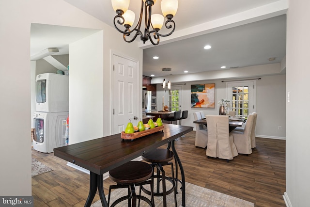 dining space with recessed lighting, dark wood-style floors, stacked washing maching and dryer, baseboards, and a notable chandelier