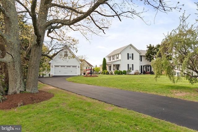 colonial home featuring driveway and a front lawn