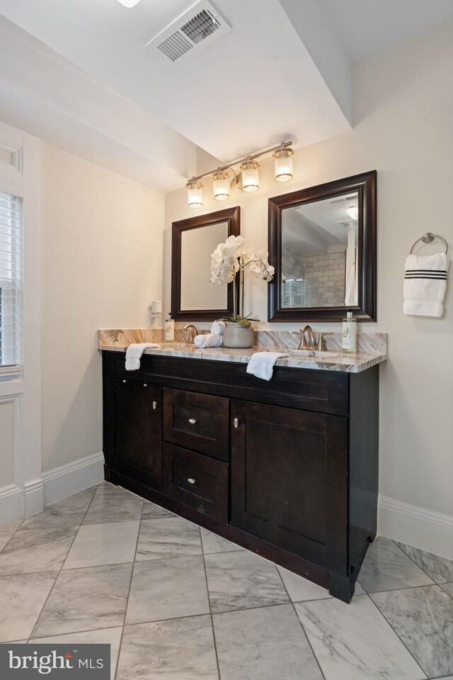 bathroom with visible vents, baseboards, marble finish floor, and double vanity