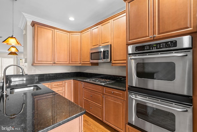 2415 Saint Paul St, Baltimore, MD 21218 - kitchen with stainless steel appliances, a sink, dark stone counters, decorative light fixtures, and light wood-style floors